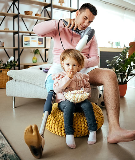 A disabled dad blow drying his young daughter's hair