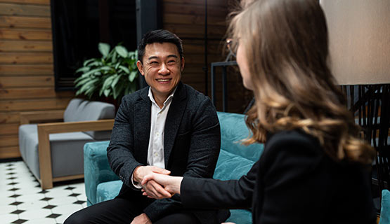 Two business people shaking hands in an office